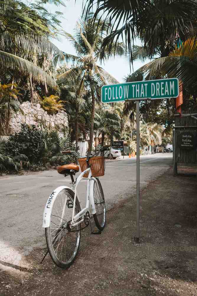 A white bicycle is standing in the side of the road of Caribbean Islands